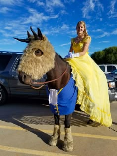 a woman in a yellow dress riding on the back of a horse