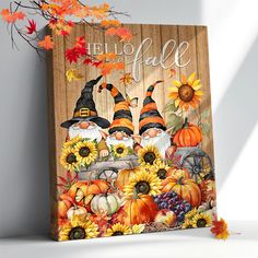 a wooden sign that says hello fall with two gnomes and sunflowers on it