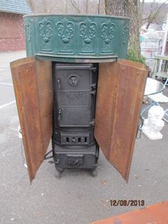 an old stove is sitting in the middle of a yard with its door open to reveal it's contents