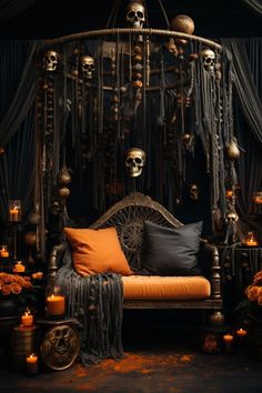 a bed with skulls hanging from it's sides and candles on the floor next to it