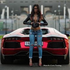 a woman standing in front of a red sports car with her hands on her hips