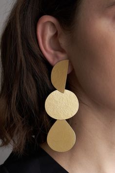 These gold Mattea earrings feature a unique, mill-textured design made with paper, that adds versatility to any wardrobe. Crafted by hand, each pair possesses its own distinctive qualities, making it a truly one-of-a-kind piece. Contemporary Handmade Brass Earrings, Modern Gold Earrings With Unique Design, Contemporary Handmade Gold Earrings, Modern Handmade Gold Linear Earrings, Moma Shoes, Annie Costello Brown, Farmhouse Pottery, Los Angeles Design, Tassel Scarf