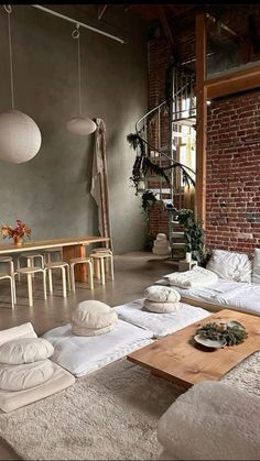 a living room filled with lots of white furniture and pillows on top of carpeted flooring