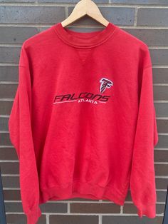 "Vintage 1990s Atlanta Falcons Crewneck Pullover Sweatshirt - Missing Tag (Length 27\" Chest 23\") - FITS LIKE A LARGE - Overall great vintage condition - Message for more information Please take note of the measurements listed as these are vintage clothes and may fit different than the tag size. Follow our page for more vintage clothing drops! Connect with us on Instagram: @recurarchives" Falcons Svg, 90s Football, Sweater Streetwear, Vintage Pullover, Champion Shorts, Vintage Pullovers, Vintage Sportswear, 90s Shirts, Champion Reverse Weave