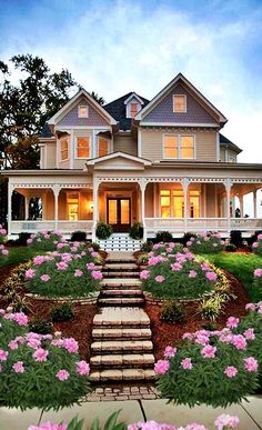 a large house with flowers in the front yard and steps leading up to it's entrance