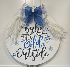 a sign that says baby it's cold outside hanging on a door hanger