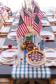 a patriotic table setting with american flags and pies