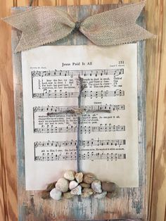 an old sheet music with a cross on it and rocks in the foreground,