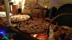 several pies and pastries are sitting on the table in front of a tent