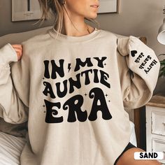 Looking for the perfect auntie gift? Look no further than our In My Auntie Era with names on Sleeve sweatshirt! This soft and comfortable sweater is ideal for any occasion.  And don't forget the kids! Our auntie sweatshirt is the perfect way to show your little ones that you love them with their names prominently displayed on the sleeve. Whether you're shopping for aunt, auntie or sister, our auntie sweatshirt is the perfect Mothers Day, birthday  or Christmas gift. So don't wait, order your sweater today! * S I Z I N G * ✺ Sizing is unisex  ✺ For adults, size runs like men's, though not overly large. Most women find their typical size works best, since they are meant to fit a touch loose and go up 1 or 2 sizes if you want the oversized look. ✺ Size guide and fit:  The size chart is listed Aunt Sweater, Auntie Sweatshirt, Auntie Era, Photography Shirts, Cool Aunt, Ultrasound Tech, Little Sister Gifts, New Aunt, Auntie Gifts