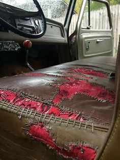 the interior of an old truck with red and black leather upholstering on it