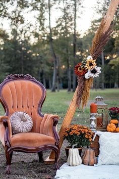 an orange chair sitting on top of a grass covered field next to a wooden pole