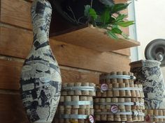 several vases and jars are stacked up on a shelf next to each other in front of a wooden wall