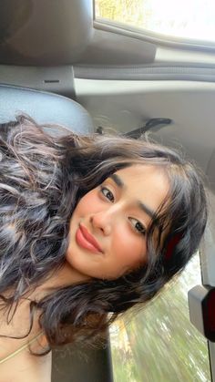 a young woman sitting in the back seat of a car looking up at the camera