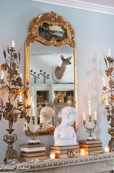 a mantle with candles and a mirror on it