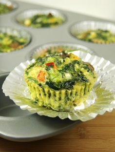 a muffin tin filled with broccoli and carrots