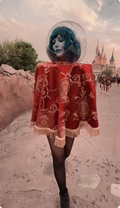 a woman in a red dress and black boots is standing on the street with a bubble over her head