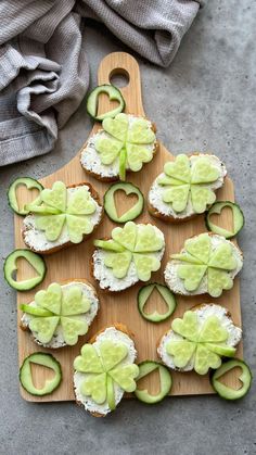 cucumber and cheese appetizers are arranged on a cutting board