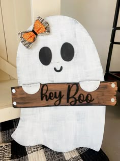 a wooden sign that says hey boo with a bow on it's head and eyes