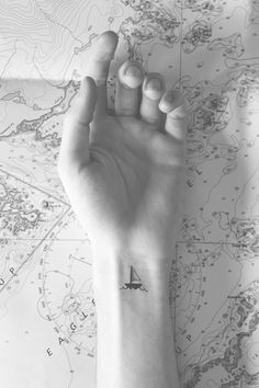 a person's arm with a small airplane tattoo on the left side of their wrist