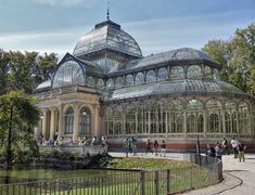 people are walking around in front of a glass house