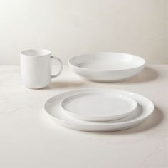 two white plates and a cup on a table