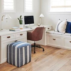 a home office with white walls and wooden floors