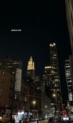 a city street at night with tall buildings in the background