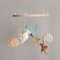 a baby mobile with sea animals and seashells hanging from it's sides