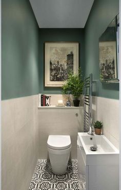 a white toilet sitting in a bathroom next to a sink and bathtub under a window