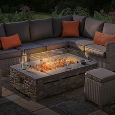 an outdoor fire pit surrounded by wicker furniture