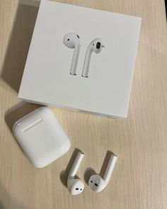 an apple airpods sitting on top of a table next to two other earbuds