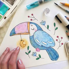 a drawing of a blue bird with an umbrella on it's head, surrounded by markers and crayons