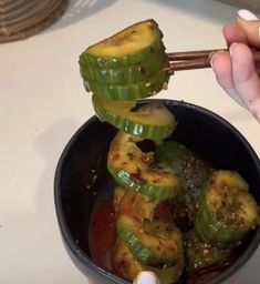 someone is holding chopsticks over some food in a bowl