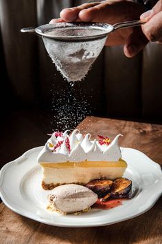 a piece of pie on a plate being sprinkled with sugar