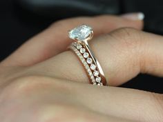 a woman's hand with a diamond ring on top of her finger and an engagement band