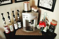 a coffee maker sitting on top of a counter next to bottles