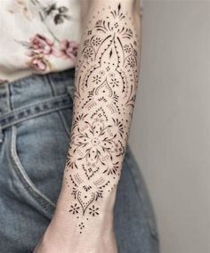 a woman's arm with a tattoo on it, and an intricate design in the middle