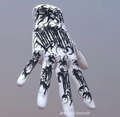 a hand with black and white designs on it