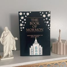 the book of mormon sits on a shelf next to other figurines and books