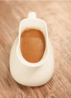 a cup filled with liquid sitting on top of a wooden table