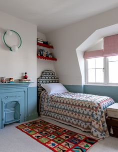 a bedroom with a bed, dresser and rug in it's corner next to a window