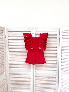 Red girls neoprene/ scuba romper with ruffles and pockets/ Casual romper/ Girls casual wear/ Ruffles jumpsuit/ Custom pageant outfit This beautiful romper is made out of neoprene/scuba fabric. This material is stretchy and it has a shape. The romper has zipper back. It looks amazing with ruffles. It is decorated with buttons.  It is easy to care and comfortable to wear. The romper is perfect for every important event and as casual wear. It is absolutely stunning on!  Materials Neoprene  Colors and sizes The romper can be made in any color and size.  Message me and I'll happily send you a color chart. Offer more than 10 different colors to choose from.  All items are made to order.  Romper is tailored to order in any standard size.  The size chart is the picture of the listing. If you want Fitted Red Bubble Romper With Ruffles, Red Chic Jumpsuits And Rompers With Ruffles, Chic Red Jumpsuit With Ruffles, Sleeveless Fitted Bubble Romper For Party, Fitted Sleeveless Bubble Romper For Party, Fitted Ruffle Jumpsuits And Rompers, Fitted Ruffled Overalls Jumpsuits And Rompers, Fitted Ruffles Jumpsuit Overalls, Pageant Casual Wear