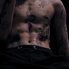 a shirtless man with tattoos on his chest