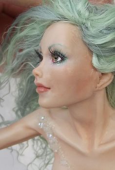 a doll with green hair and blue eyes