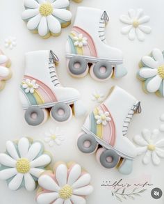 decorated cookies in the shape of roller skates and daisies on a white surface