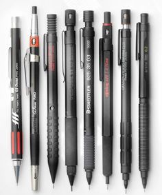 several different types of pens lined up on a white surface