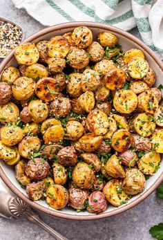 a bowl filled with roasted potatoes and herbs