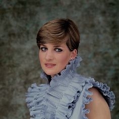 a woman with short hair wearing a blue dress