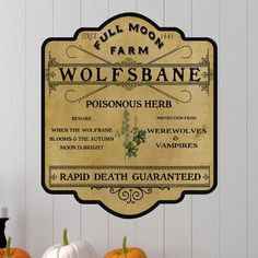 a sign on the wall that says wolfsbane with pumpkins in front of it